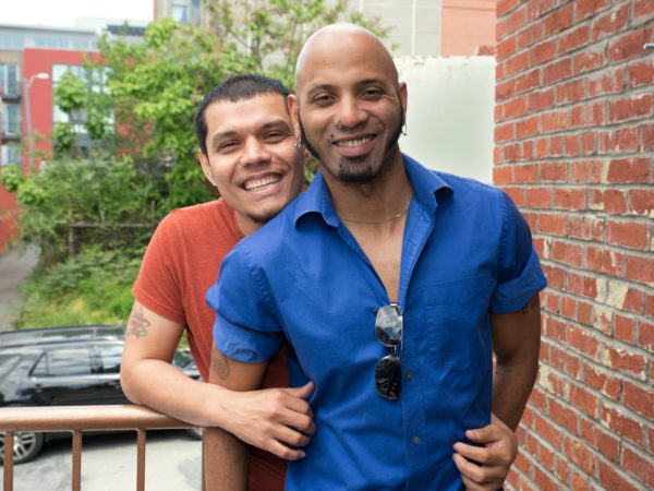 Two men hugging and smiling